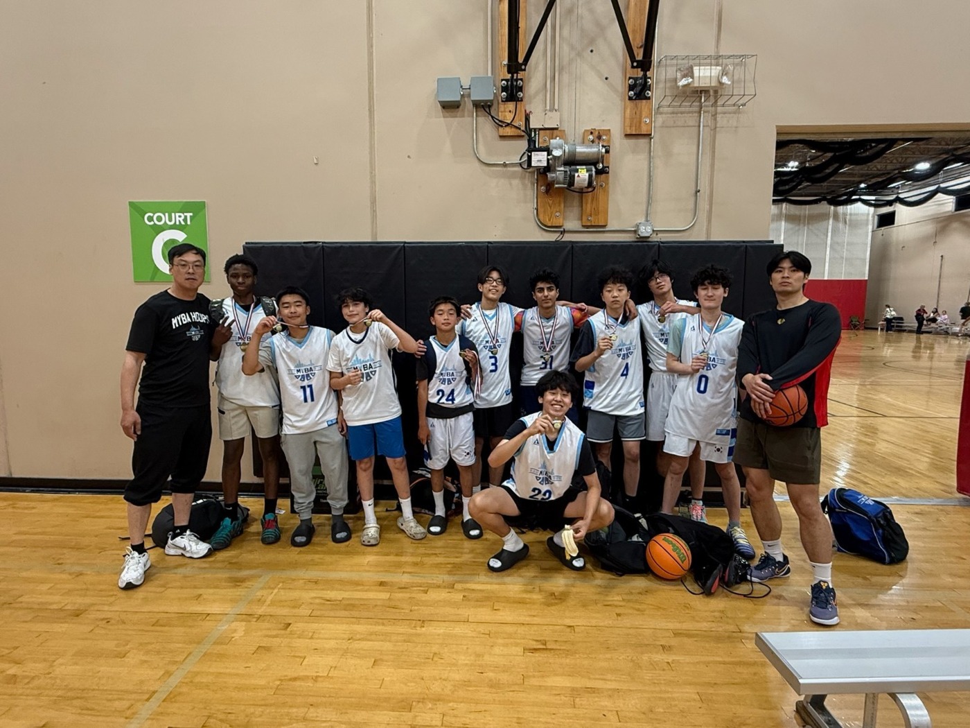 MYBA players and coaches celebrating together with medals