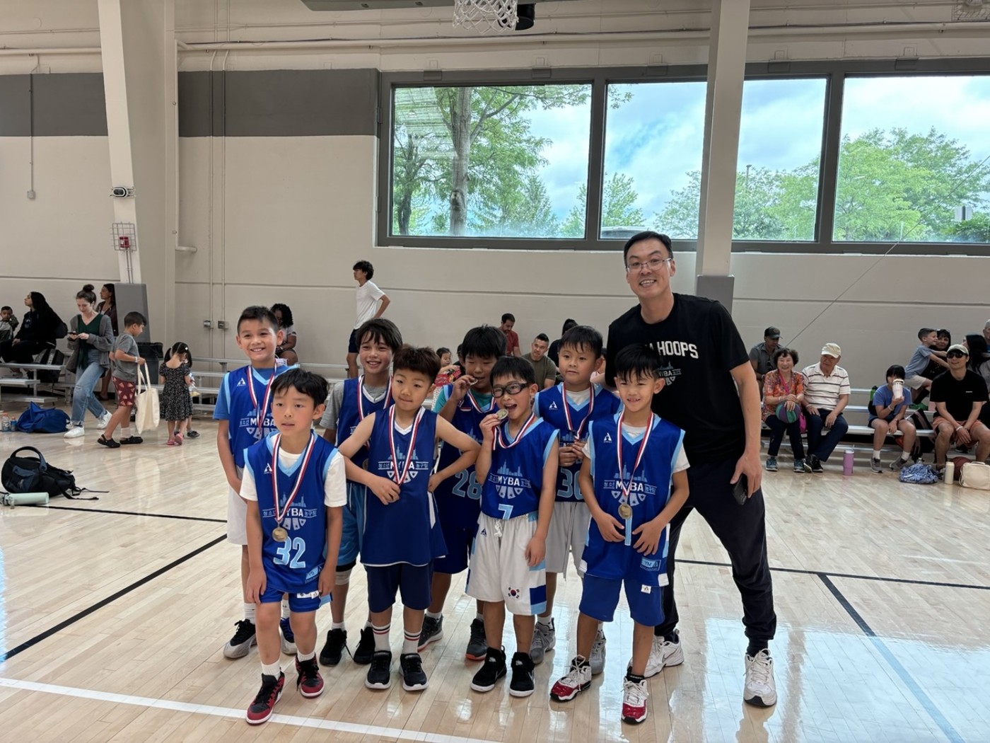 Younger MYBA players and Coach Mark celebrating with medals